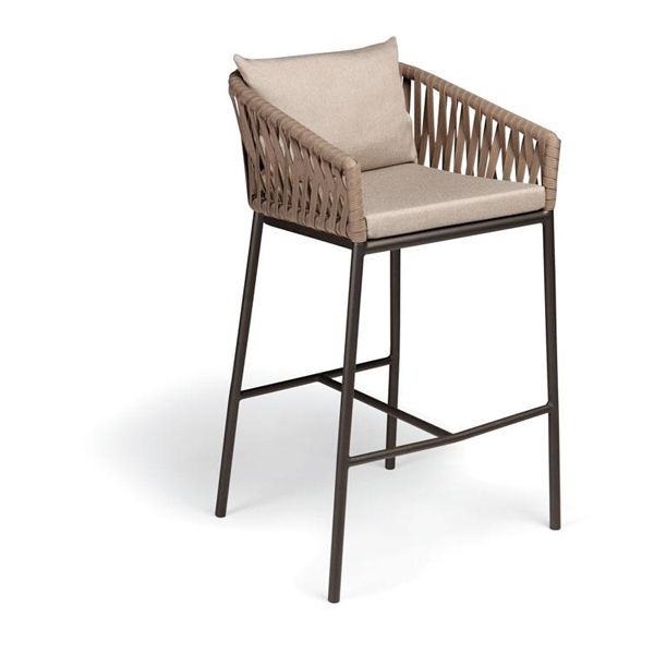 La colección Bitta de Kettal ha sido diseñada por Rodolfo Dordoni y se caracteriza por una combinación de estructuras de aluminio, con asientos trenzados con cuerda de poliéster y cómodos cojines, madera de teka y piedra para los sobres de mesa. Construidos con materiales resistentes a la intemperie.
Bitta significa â€œamarraderoâ€ en italiano, ya que el trenzado de las sillas recuerda al que se utiliza para amarrar las barcas en los amarraderos.
Las piezas ofrecen una sensación de ligereza y además sus tonos naturales hacen que parezcan nidos acogedores con los que relajarse.
Más información sobre esta colección ennaharro.